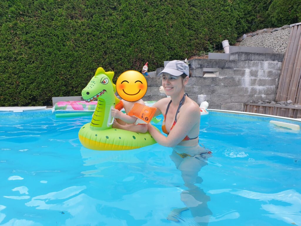 Frau mit Kind und Schwimmtier im Pool